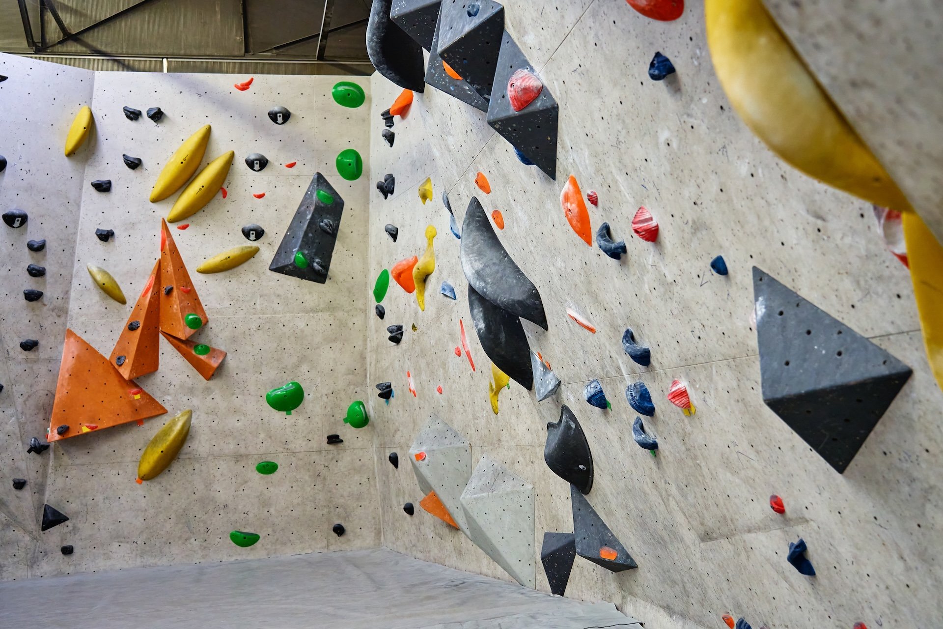 Wall for bouldering in gym with holds for climbing.