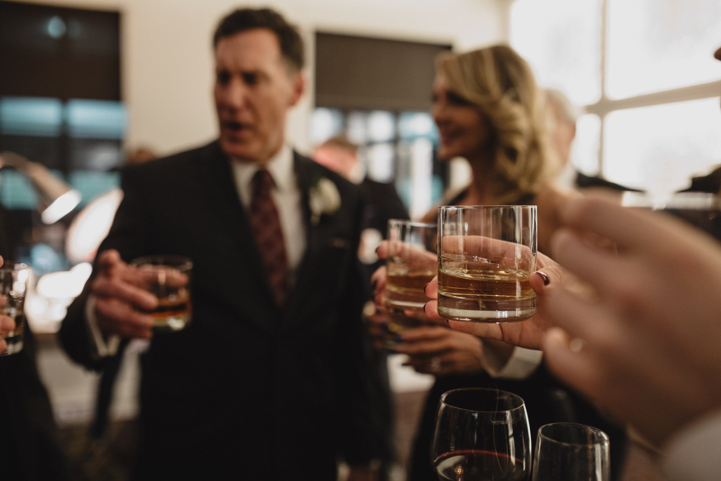 Formally dressed people gathering and cheering their liquor