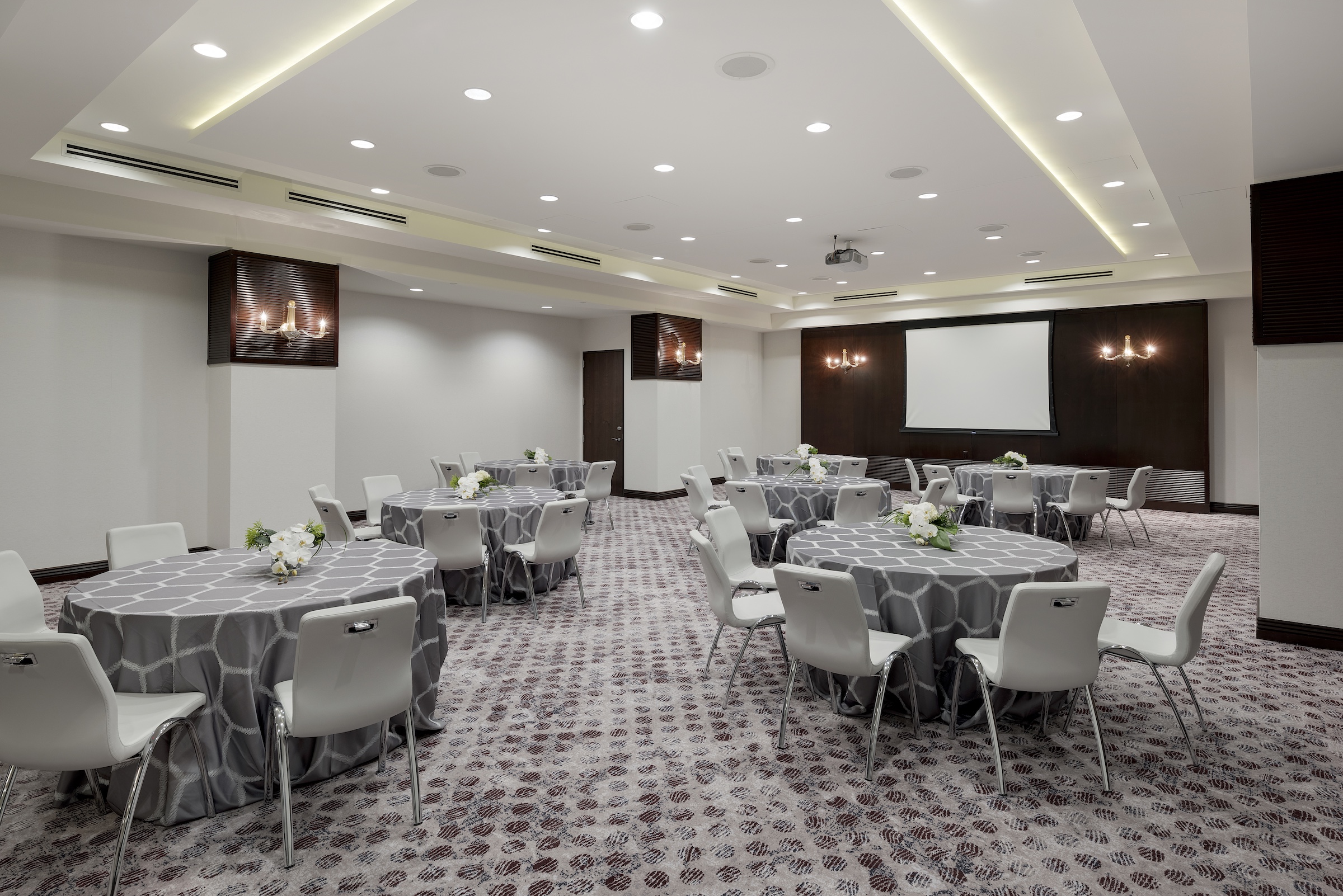 Round tables with grey cloth and chairs in a modern stylish meeting space, Grand Salon of Hotel Ivy