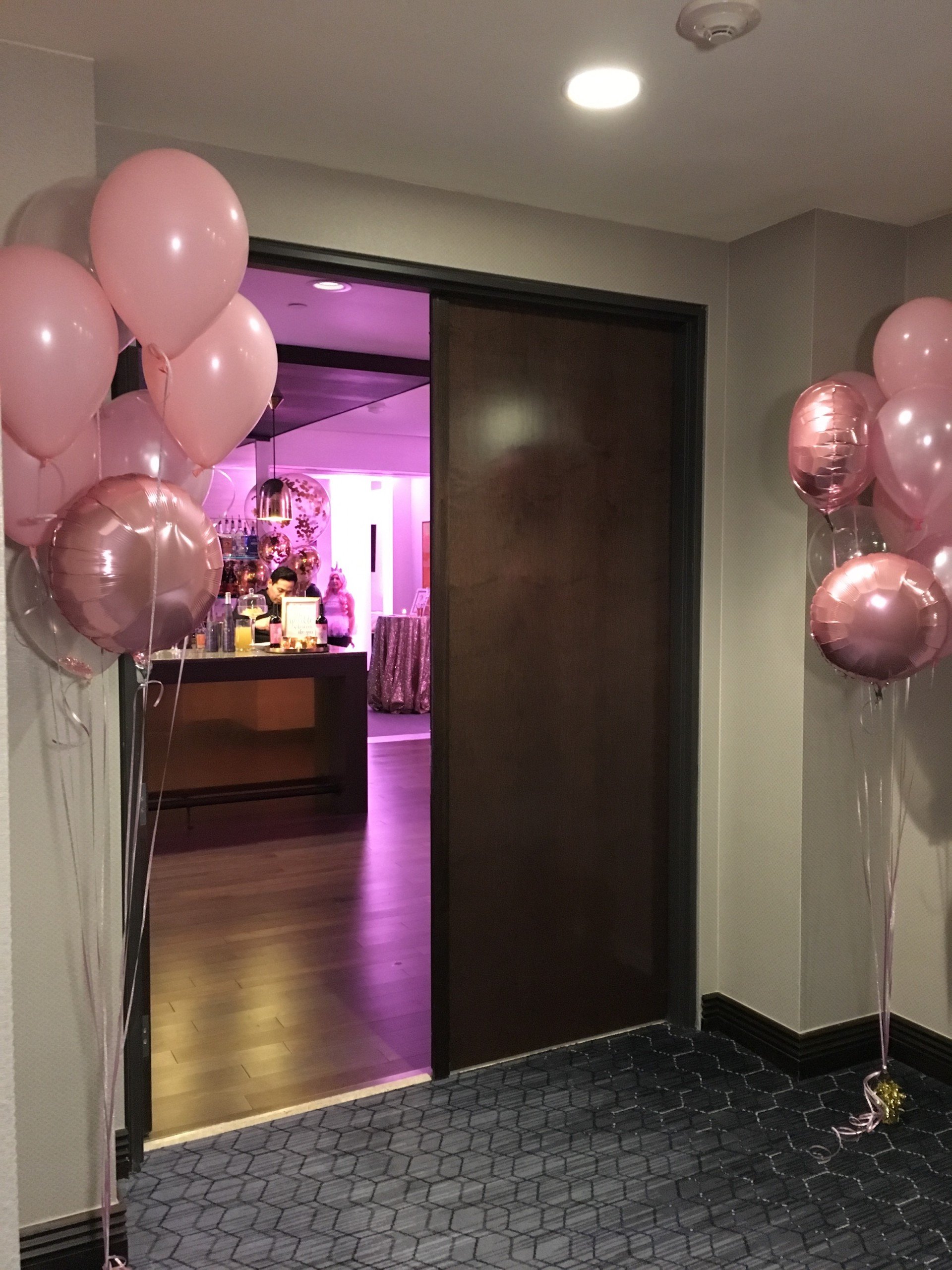 The entrance of Penthouse Suite at Hotel Ivy, welcoming guests with pink helium balloons