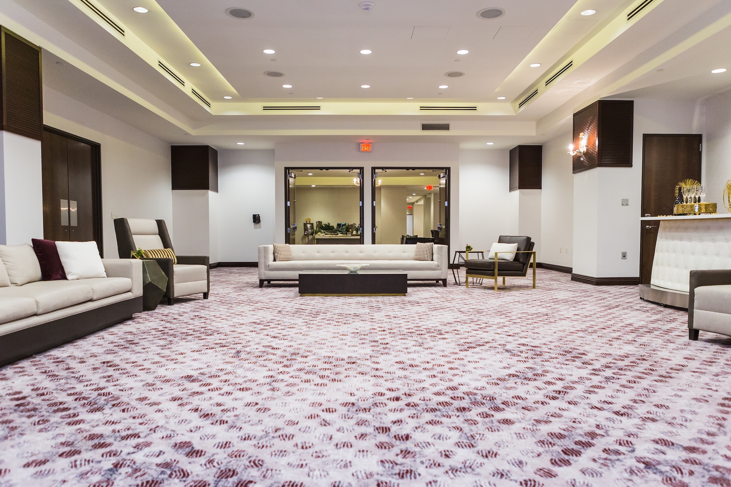 Couches, chairs, tea table, reception, etc. in a large meeting space with two door entrances at Pre-function Space, Hotel Ivy