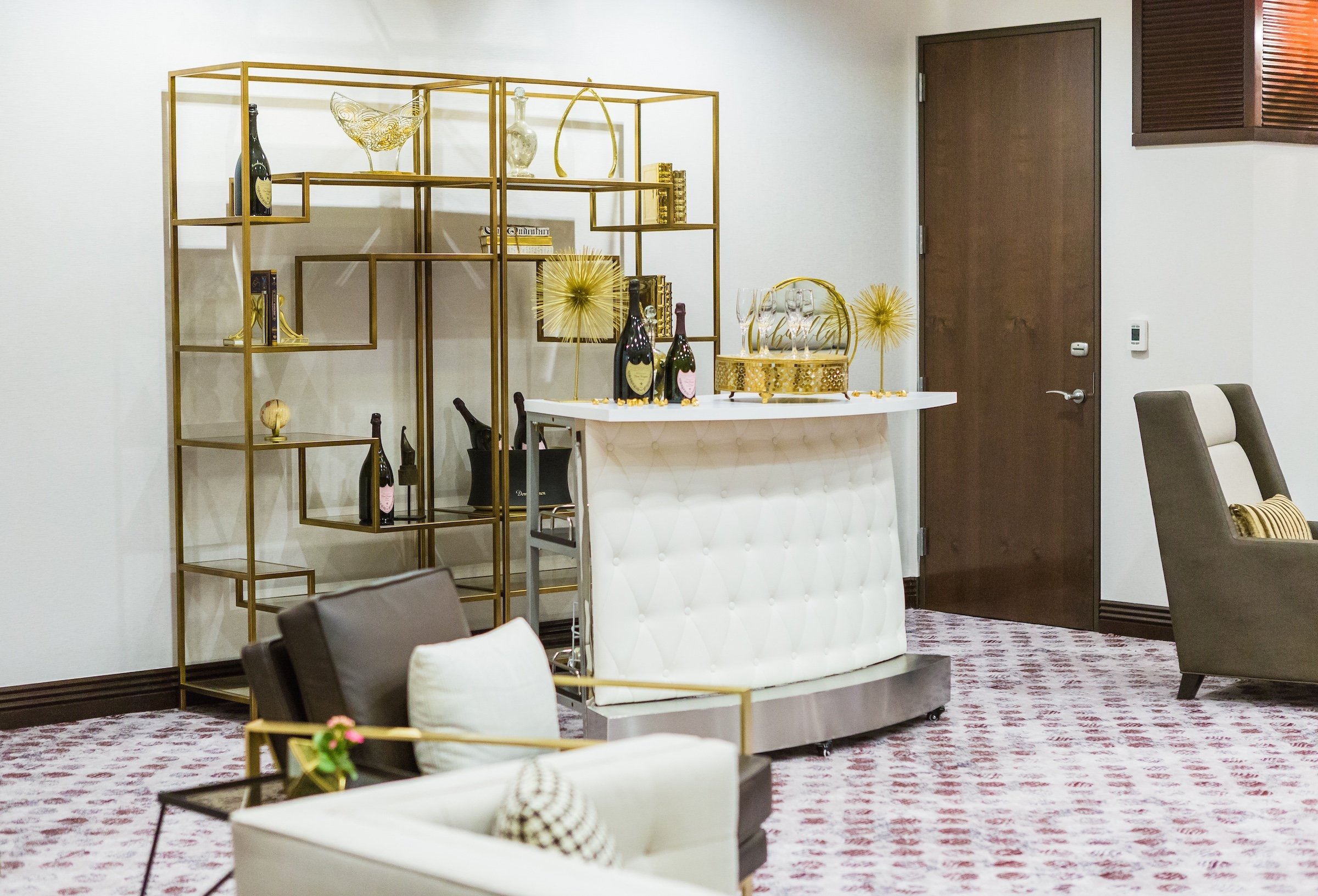 Liquor tables with golden decorations on a white reception table in a large venue, Pre-function Space at Hotel Ivy