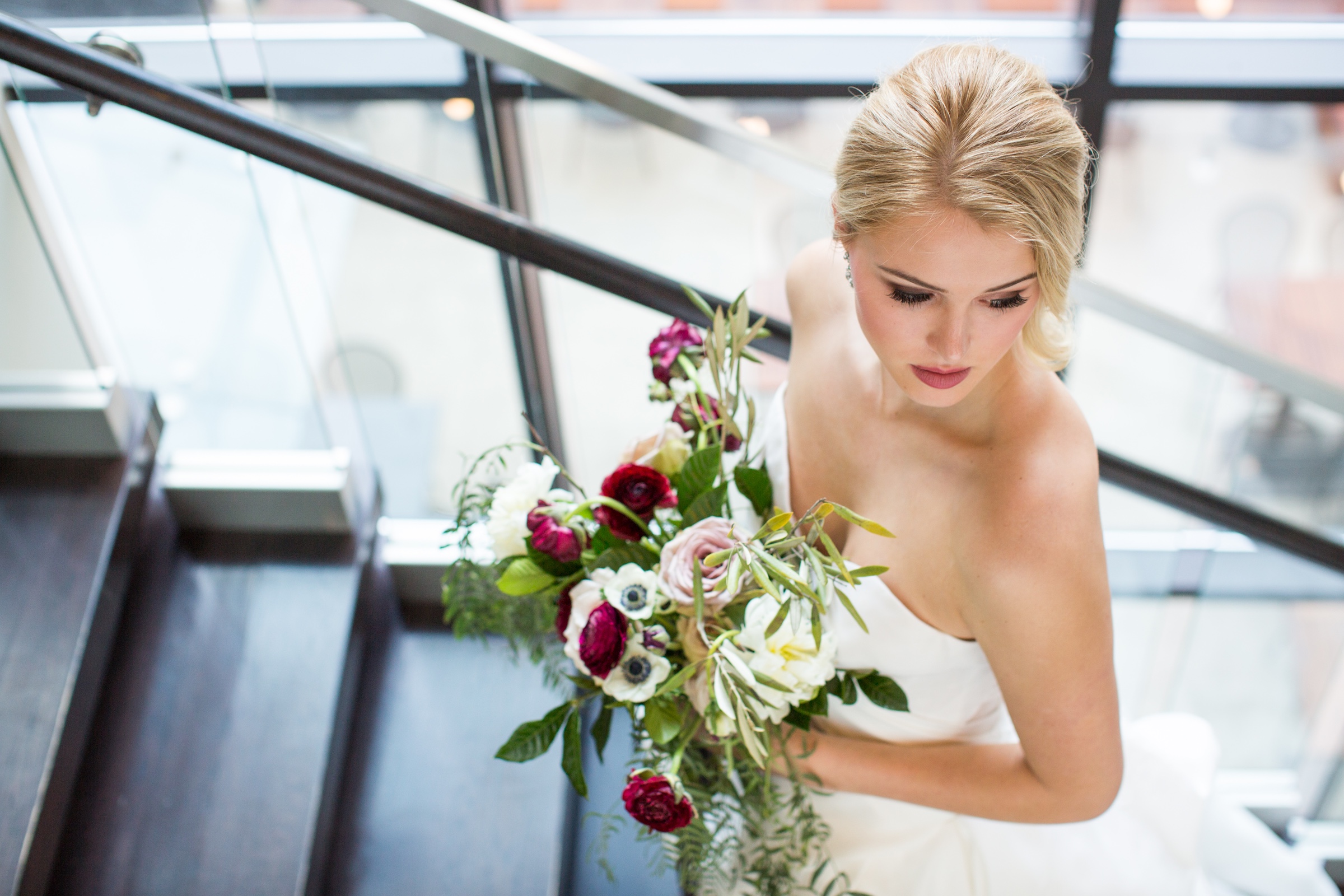 Beautiful bride with bouquet of roses walking stairs