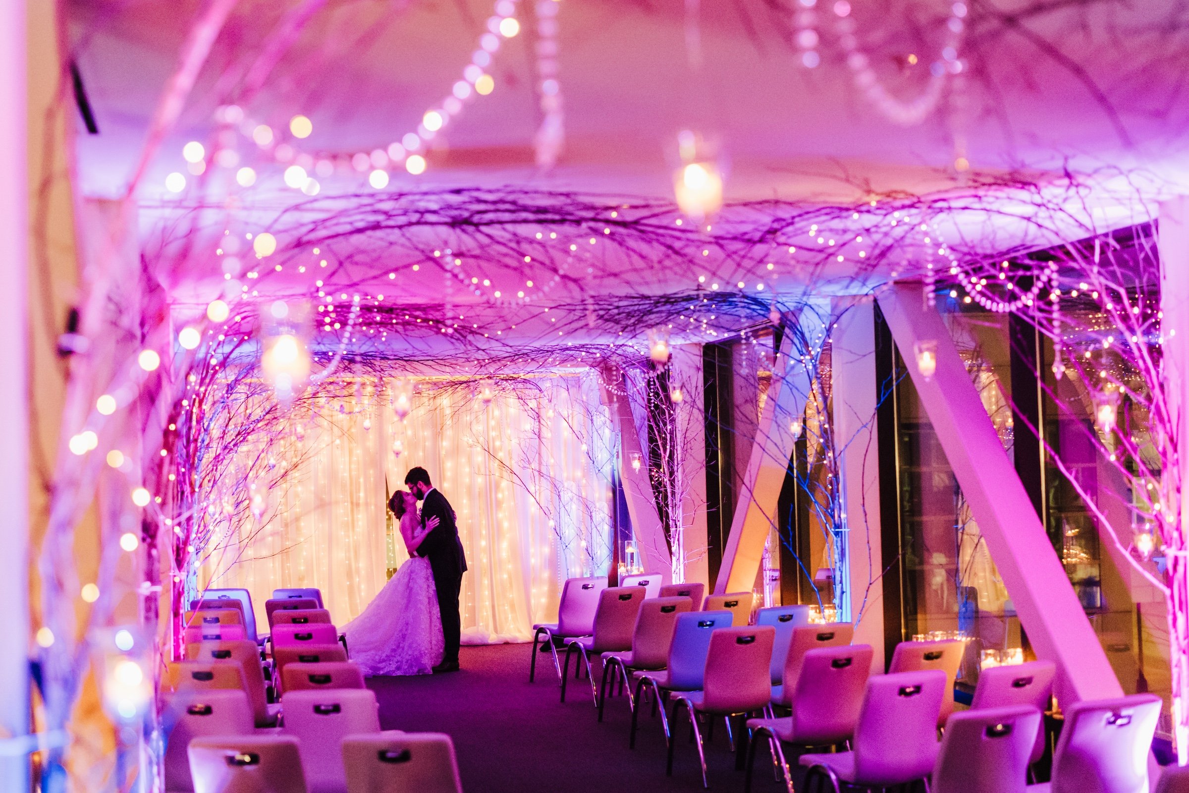 Granby & Sprung's wedding - Couple kissing in the purple lighting wedding venue