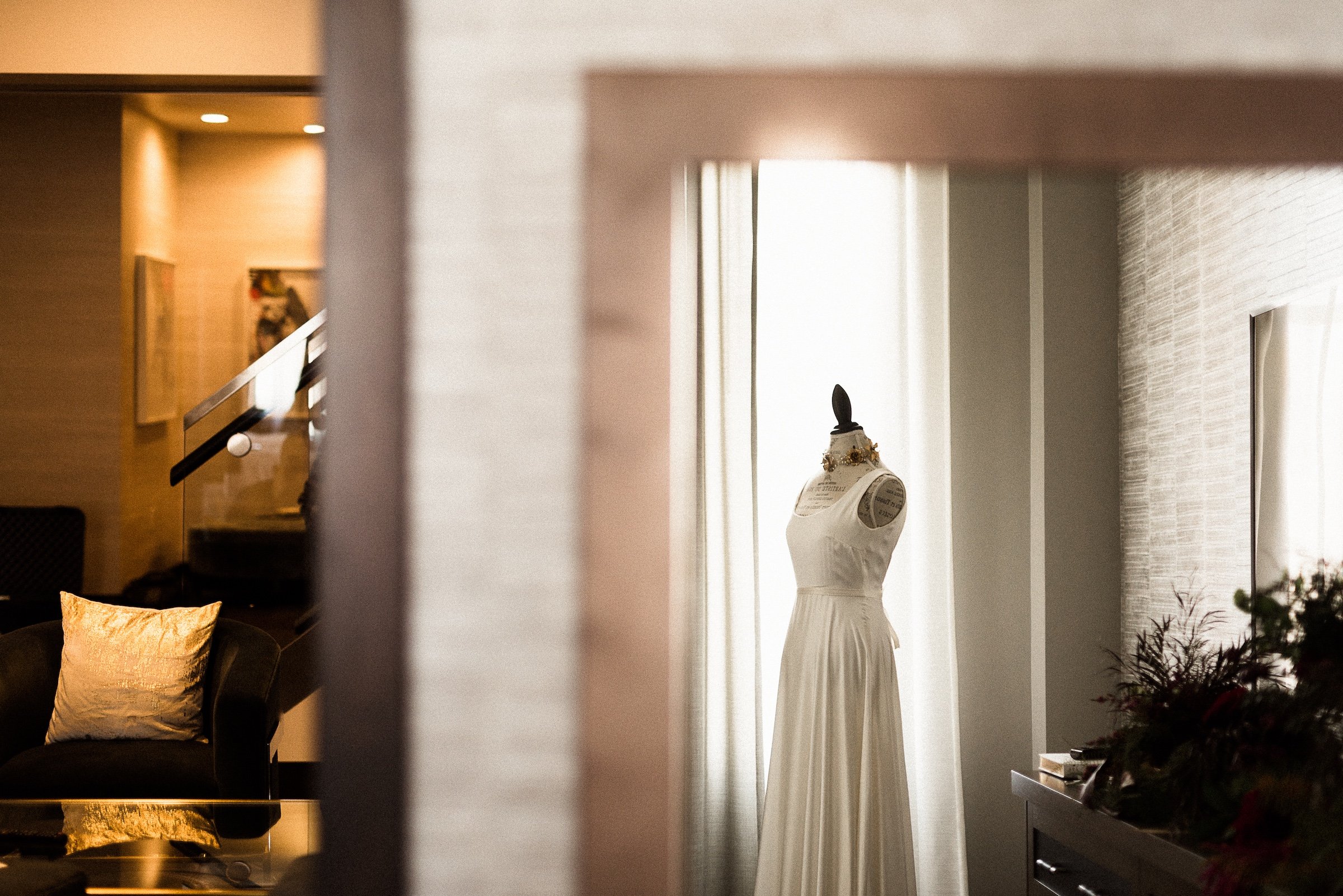 A photoshoot focusing on a white wedding dress in a large room at Hotel Ivy