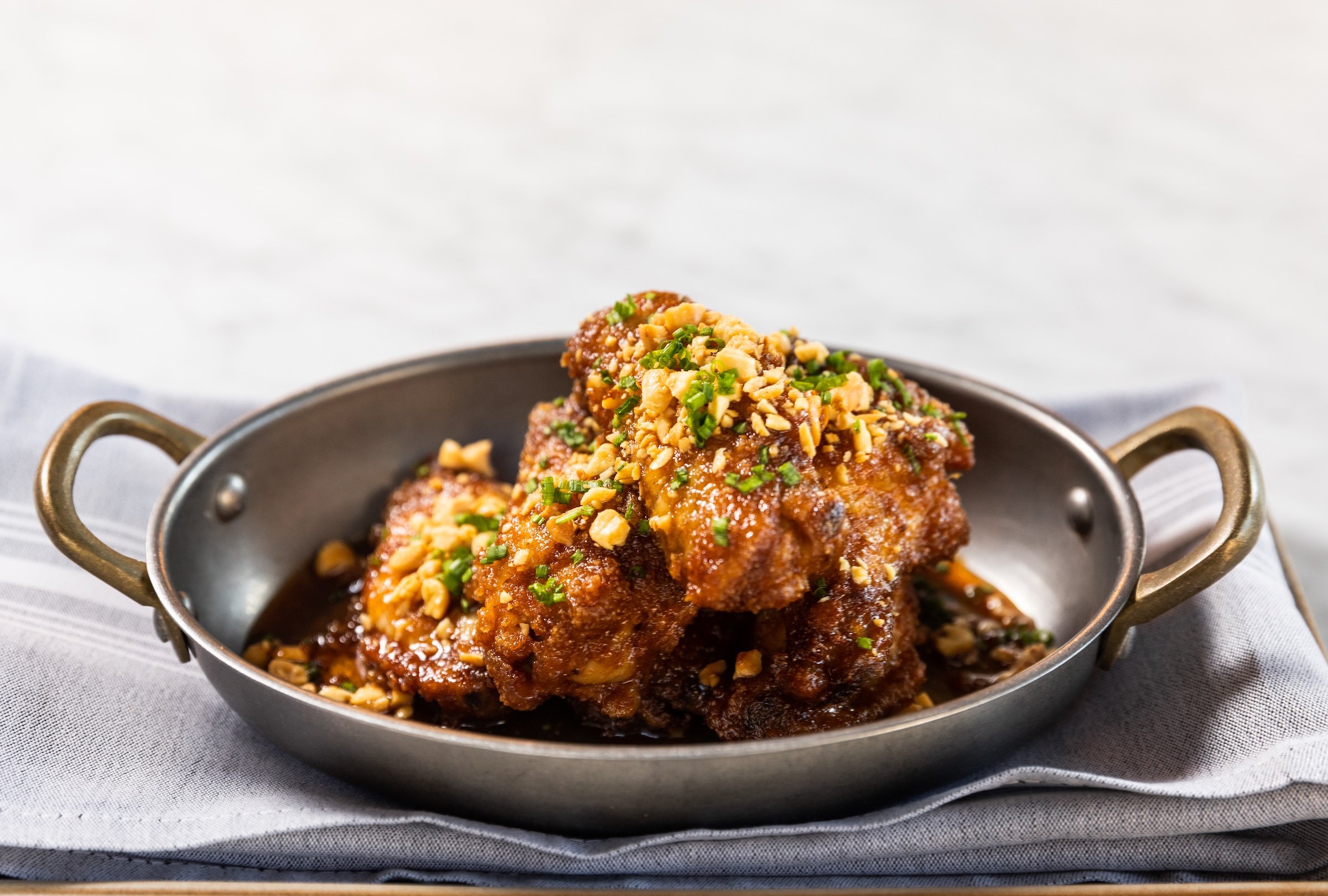 Honey Chicken wings on a white marble table at Breva, Hotel Ivy