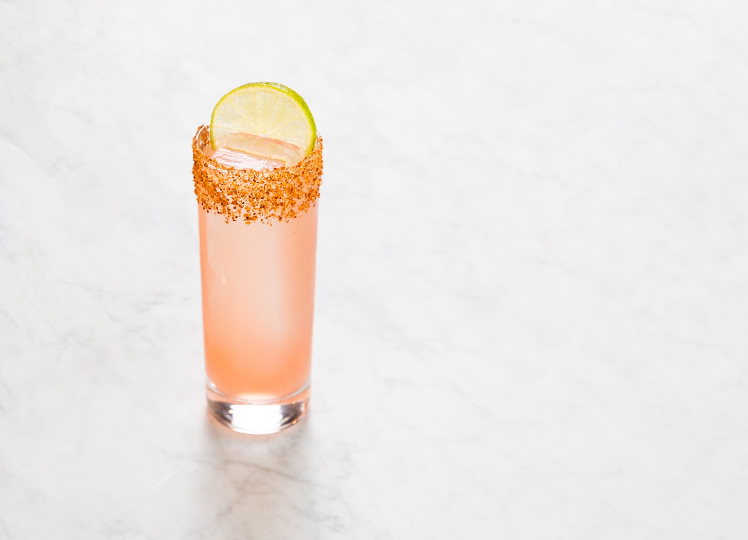 Spicy Paloma on a white marble table at Breva, Hotel Ivy