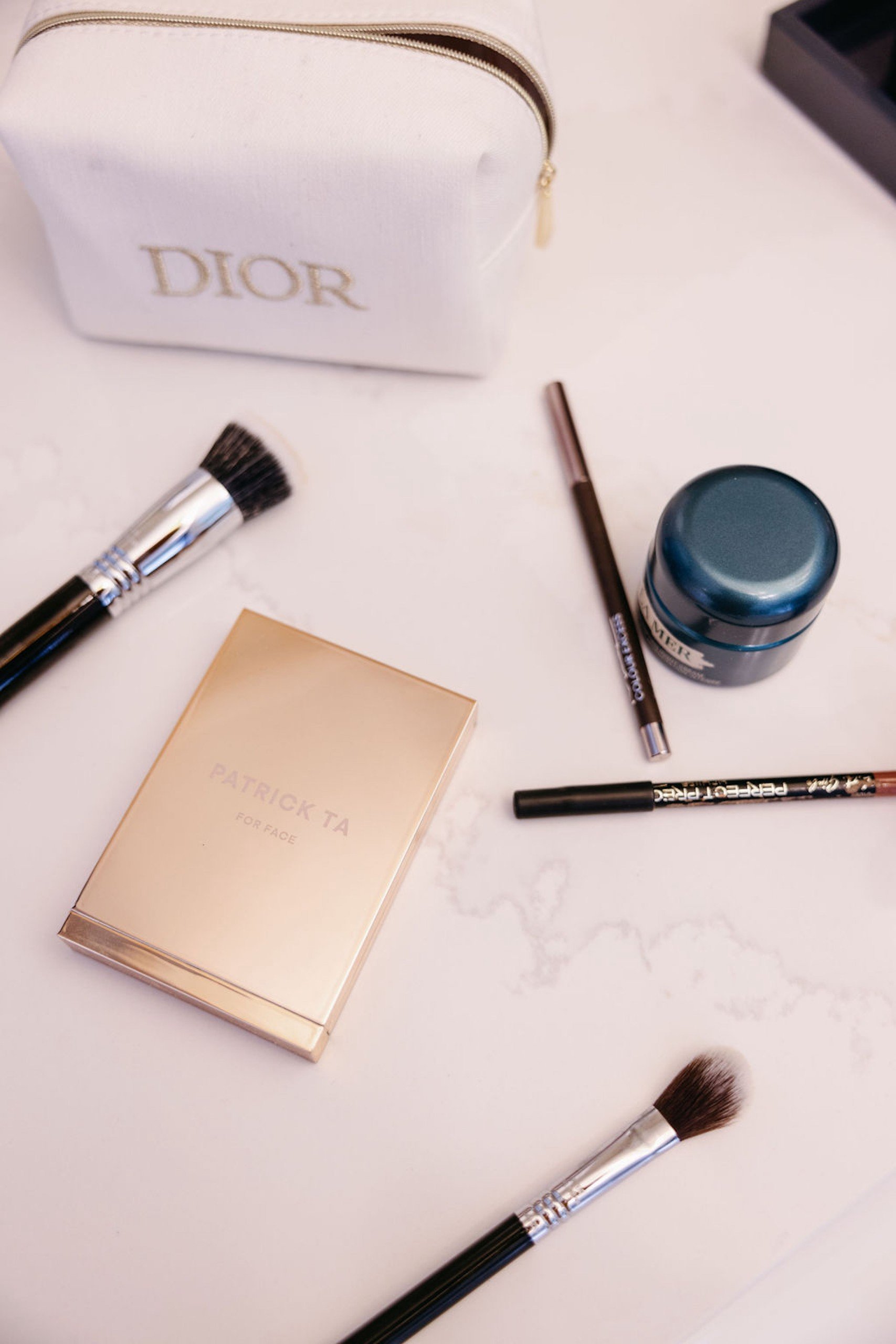 Make up product with Dior pouch on a white marble desk at Hotel Ivy