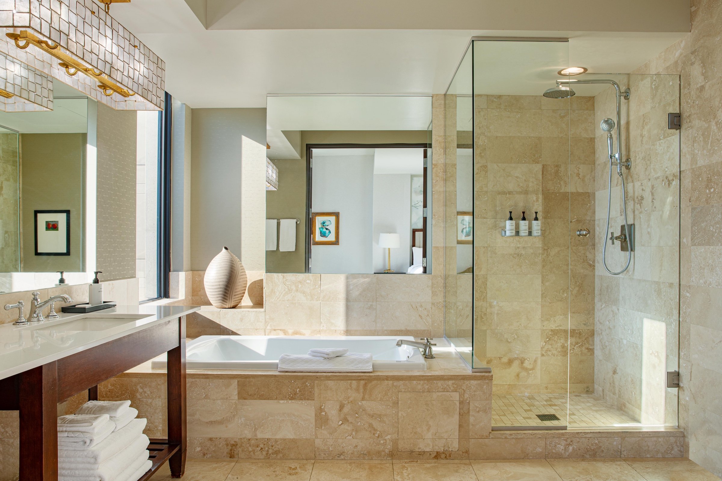 A large bright bathroom with a rainfall shower booth, a white bathtub and a sink at Hotel Ivy